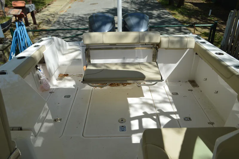 Slide: The Image of 2018 Pursuit DC 295 Dual Console boat interior with seating and storage compartments. - 16