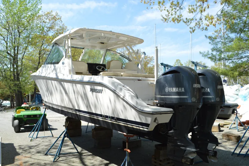 Slide: The Image of 2018 Pursuit DC 295 Dual Console boat with twin Yamaha engines on stands. - 4
