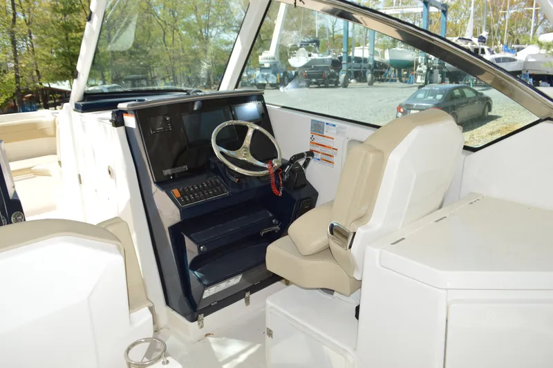 Slide: The Image of 2018 Pursuit DC 295 Dual Console boat interior with steering wheel and control panel. - 8