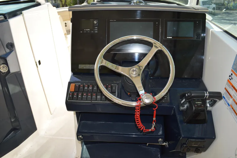 Slide: The Image of Steering console of 2018 Pursuit DC 295 Dual Console boat with controls and displays. - 9