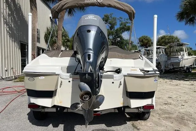 Slide: The Image of 2018 NauticStar 203SC Sport Deck boat with Yamaha outboard motor, parked outdoors. - 1