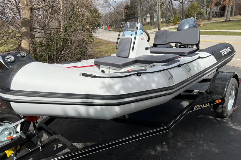 Slide: The Image of 2023 Zodiac Open 4.2 inflatable boat on trailer, parked outdoors. - 12