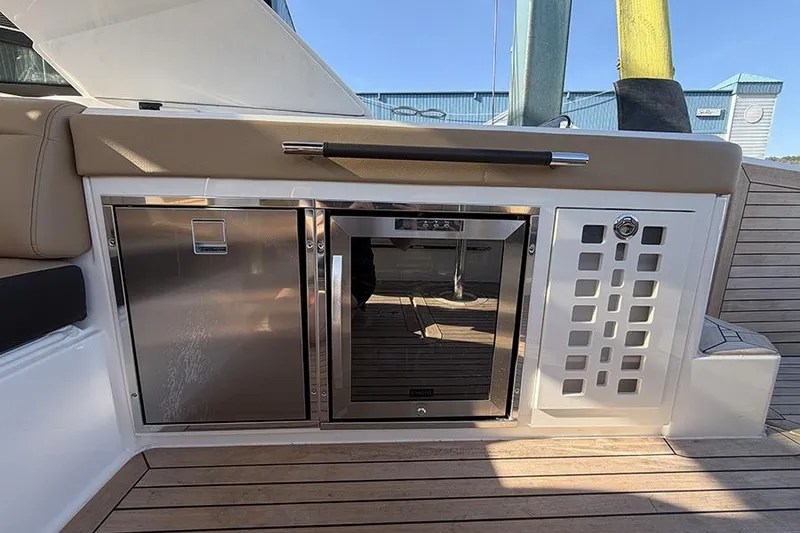 Slide: The Image of 2023 Sea Ray SLX 400 yacht interior with stainless steel appliances and teak flooring. - 17