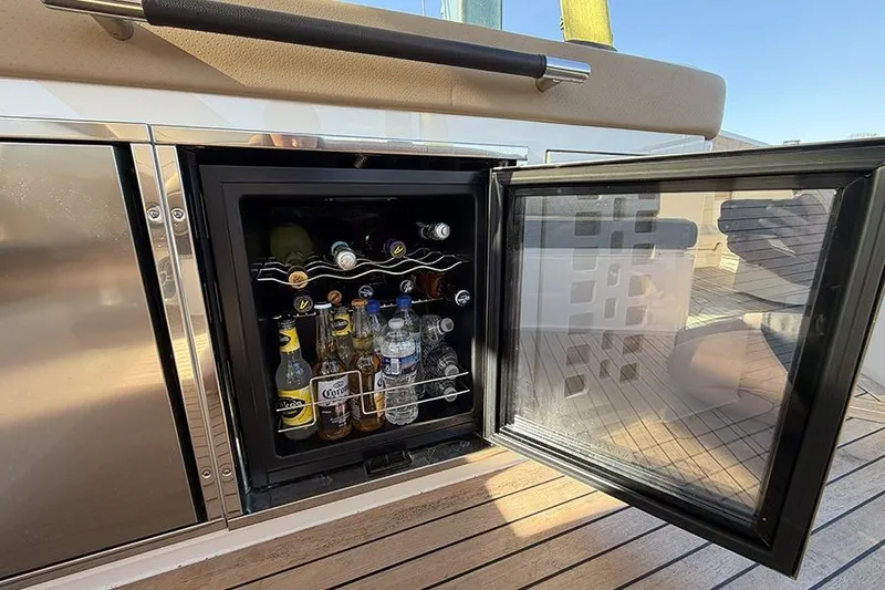 Slide: The Image of Mini fridge stocked with drinks on 2023 Sea Ray SLX 400 yacht deck. - 21