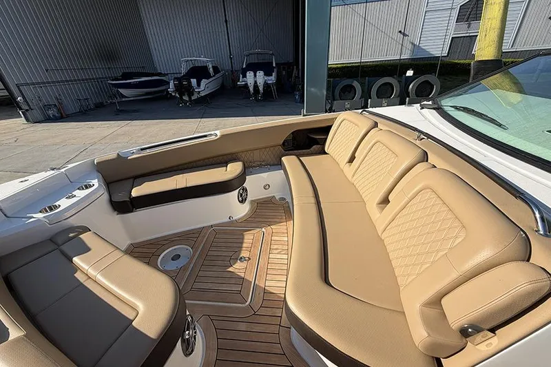 Slide: The Image of 2023 Sea Ray SLX 400 boat interior with tan seating and wooden flooring. - 36