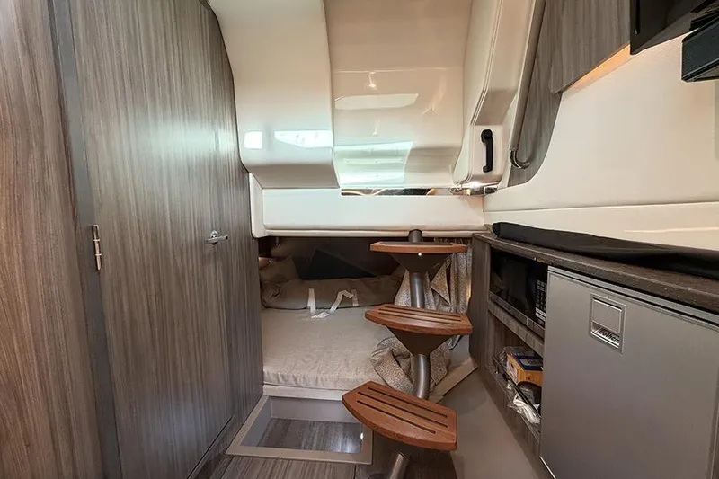 Slide: The Image of Interior cabin of 2023 Sea Ray SLX 400 boat with wooden accents and compact design. - 49