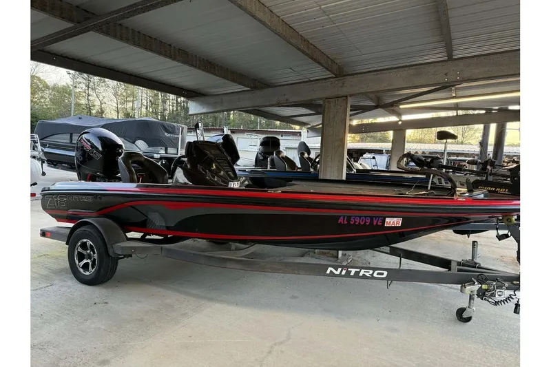 The Image of 2020 Nitro Z18 boat in storage, black with red accents, on a trailer. - 0