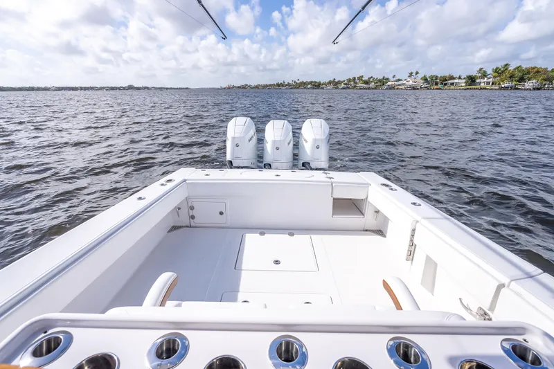 Slide: The Image of 2024 Bahama 41 boat with triple engines on open water, clear sky background. - 10