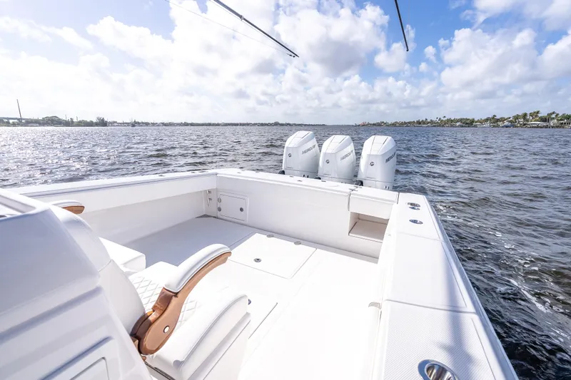 Slide: The Image of 2024 Bahama 41 boat with triple Mercury engines on open water under a cloudy sky. - 11