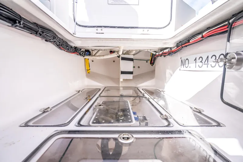 Slide: The Image of Interior view of 2024 Bahama 41 boat compartment with wiring and storage areas. - 20