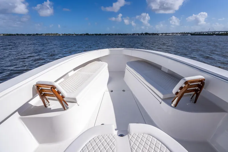 Slide: The Image of 2024 Bahama 41 boat interior with cushioned seating, on calm waters under a blue sky. - 28