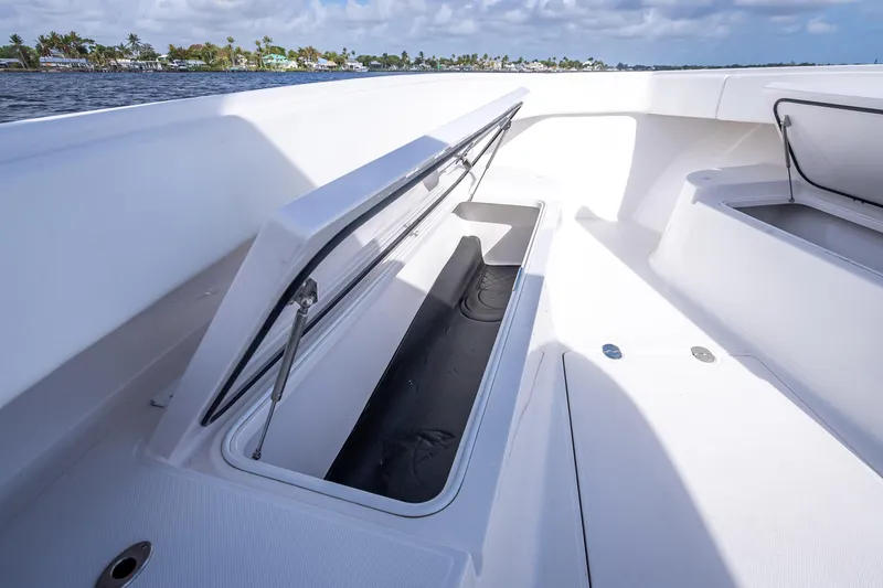Slide: The Image of 2024 Bahama 41 boat storage compartment open on deck, with scenic waterfront view. - 32