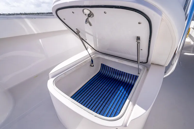 Slide: The Image of Open storage compartment on 2024 Bahama 41 boat with blue mat inside. - 38