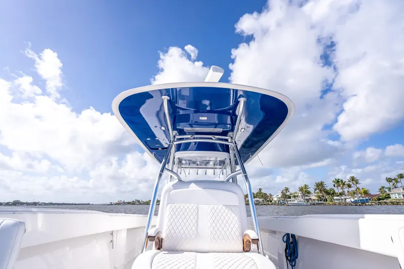 Slide: The Image of 2024 Bahama 41 boat with sleek design, blue canopy, and luxurious seating under a clear sky. - 39