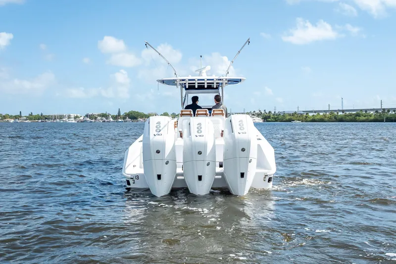 Slide: The Image of 2024 Bahama 41 boat with triple outboard engines cruising on a sunny day. - 4