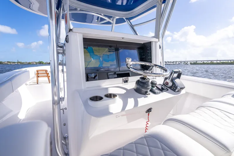 Slide: The Image of 2024 Bahama 41 boat cockpit with navigation system and steering wheel on a sunny day. - 42