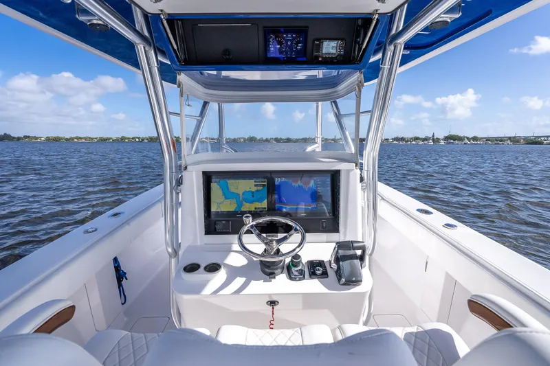 Slide: The Image of 2024 Bahama 41 boat cockpit with navigation screens, steering wheel, and ocean view. - 43