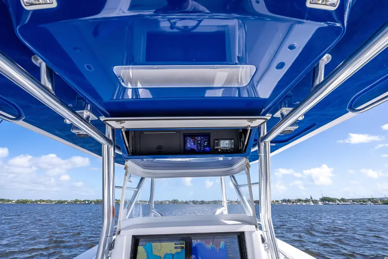 Slide: The Image of 2024 Bahama 41 boat cockpit with blue canopy and navigation equipment on open water. - 44