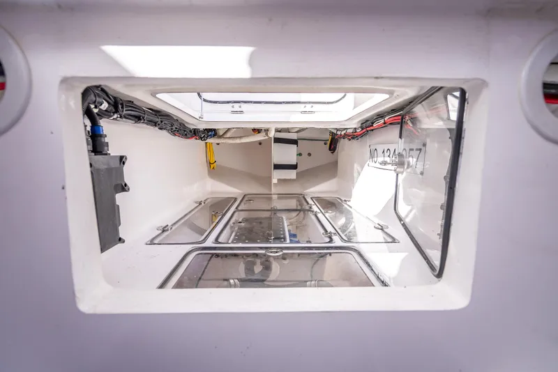 Slide: The Image of Interior view of 2024 Bahama 41 boat compartment with wiring and storage. - 54