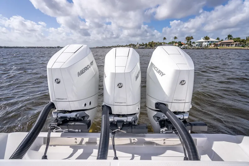 Slide: The Image of Triple Mercury Verado engines on a 2024 Bahama 41 boat, cruising on a sunny day. - 62