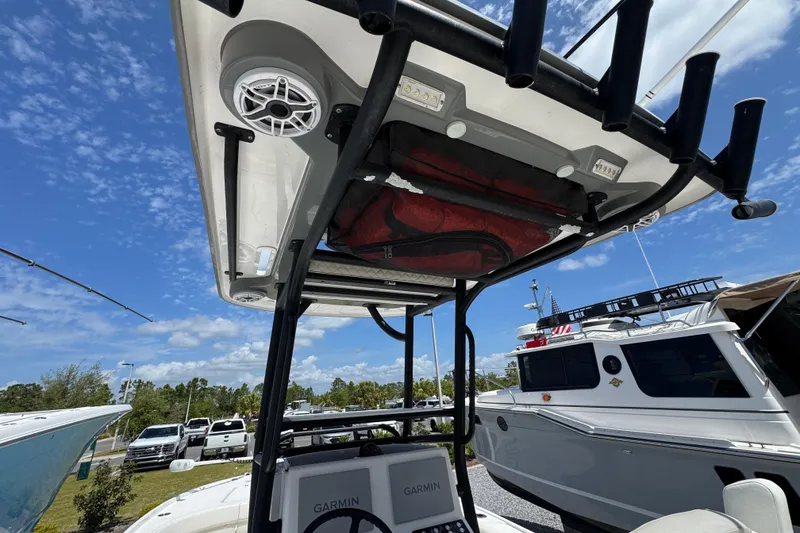 Slide: The Image of 2022 Caymas 26 HB boat with T-top, speakers, and Garmin electronics under a clear blue sky. - 11