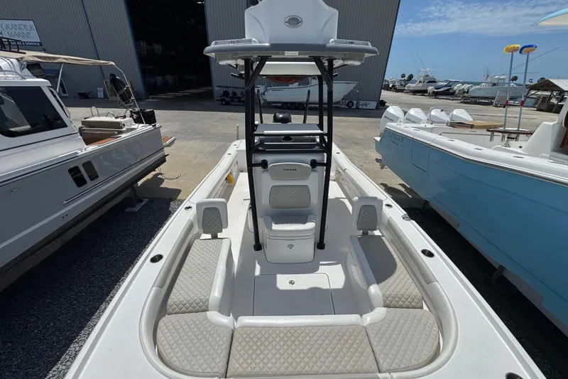 Slide: The Image of 2022 Caymas 26 HB boat with spacious deck and seating, docked at a marina. - 16