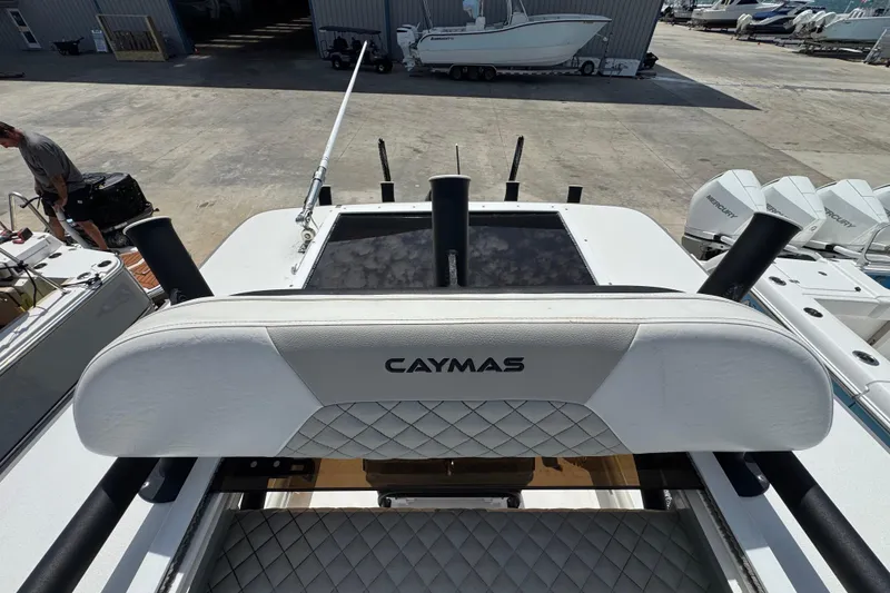 Slide: The Image of 2022 Caymas 26 HB boat with cushioned seating and rod holders in a marina setting. - 19