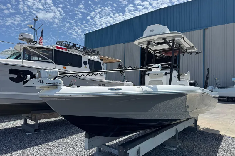 Slide: The Image of 2022 Caymas 26 HB boat on display, featuring Minn Kota trolling motor, in a marina setting. - 6