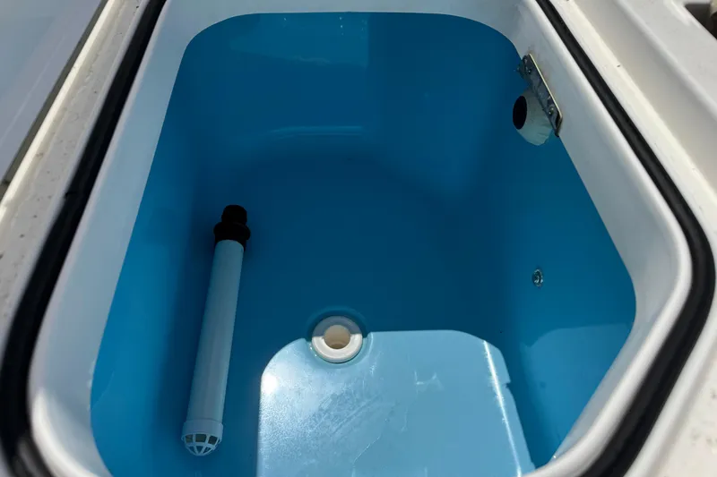Slide: The Image of 2022 Caymas 26 HB boat livewell with blue interior and drainage system. - 9
