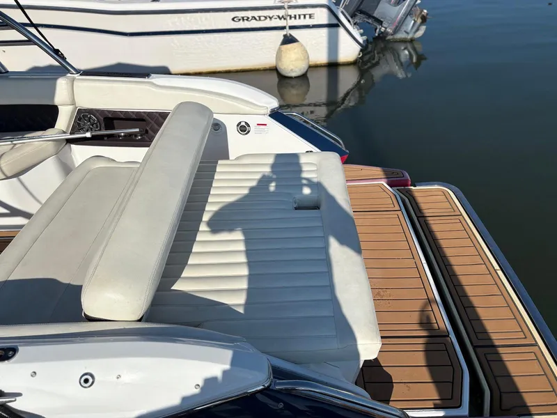 Slide: The Image of 2012 Cobalt A28 boat interior with white seating and wooden deck. - 11