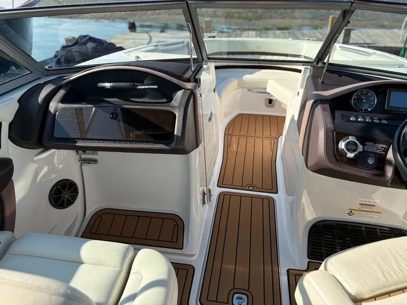 Slide: The Image of Interior of a 2012 Cobalt A28 boat with wood accents and modern dashboard. - 16