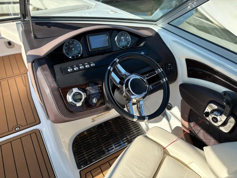 Slide: The Image of Interior of a 2012 Cobalt A28 boat featuring a sleek steering wheel and dashboard controls. - 17