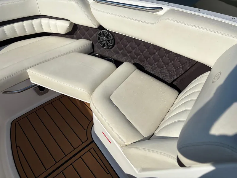 Slide: The Image of Luxurious interior seating of a 2012 Cobalt A28 boat with white upholstery and wood flooring. - 23