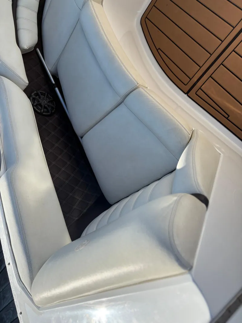 Slide: The Image of 2012 Cobalt A28 boat interior with white leather seating and wooden flooring. - 24
