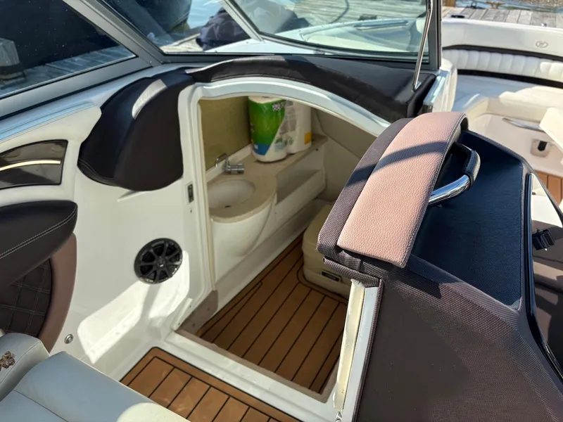 Slide: The Image of 2012 Cobalt A28 boat interior with open cabin door, showing sink and seating. - 27