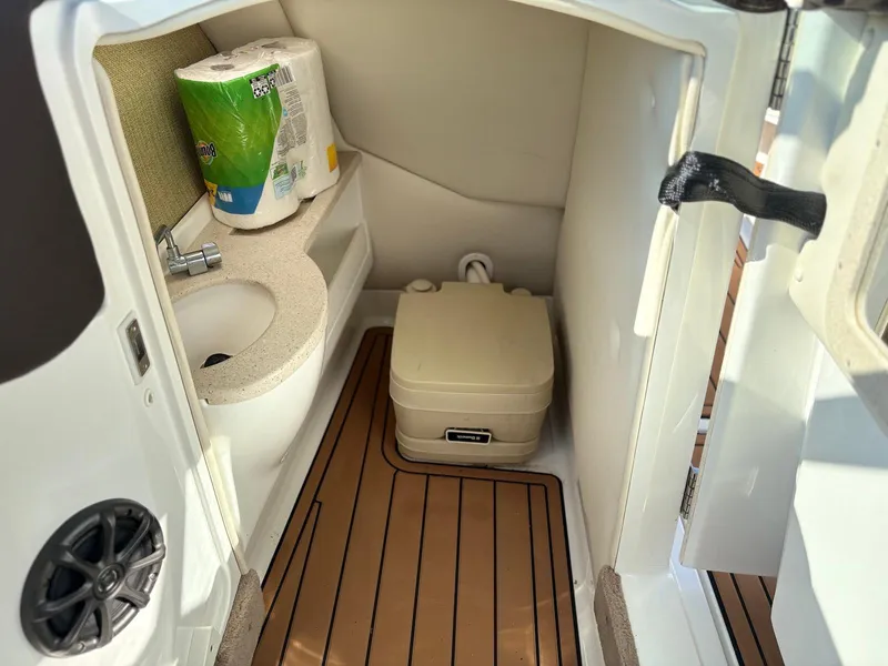 Slide: The Image of Compact bathroom in 2012 Cobalt A28 boat with sink, toilet, and wooden flooring. - 4