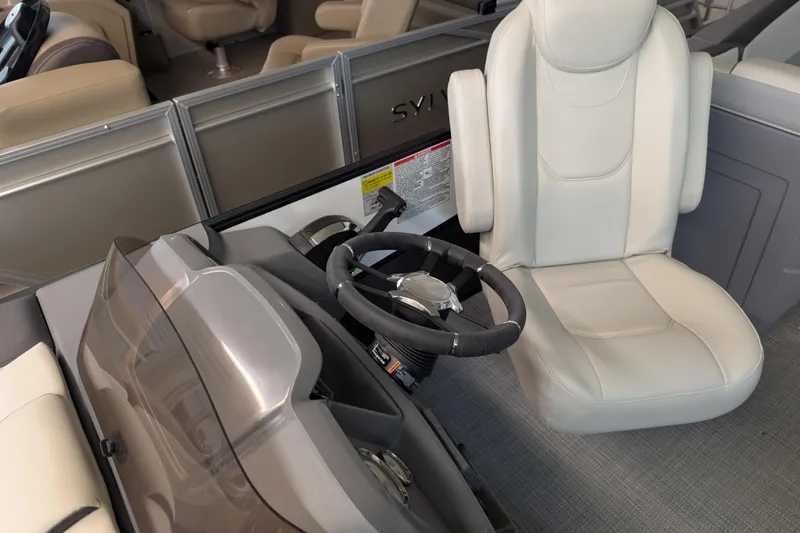 Slide: The Image of 2025 Sylvan A-Series 22 LZ DH Sport boat interior with steering wheel and captain's chair. - 4