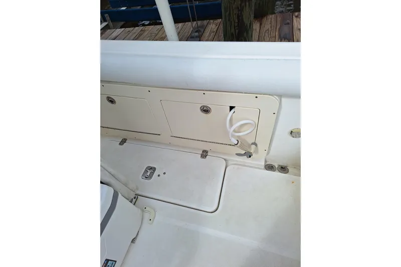 Slide: The Image of 2004 Century 2600 Center Console boat deck with storage compartments and hose. - 10
