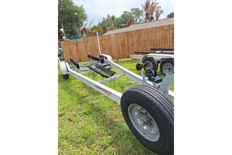 Slide: The Image of Trailer for 2004 Century 2600 Center Console boat on grass, near wooden fence. - 11