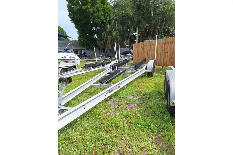 Slide: The Image of Boat trailer parked on grass beside a wooden fence, near a Century 2600 Center Console. - 12