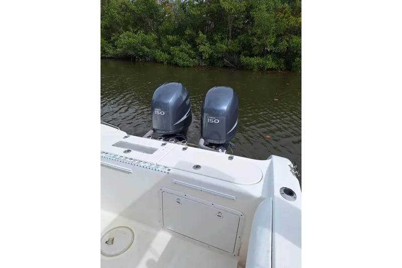 Slide: The Image of 2004 Century 2600 Center Console boat with twin Yamaha 150 engines on a calm river. - 4