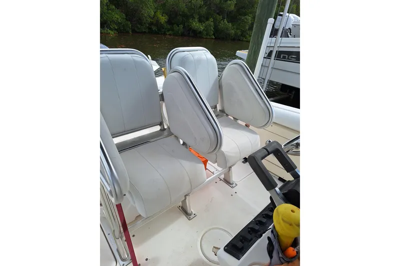 Slide: The Image of 2004 Century 2600 Center Console boat seating area with white cushioned seats. - 8