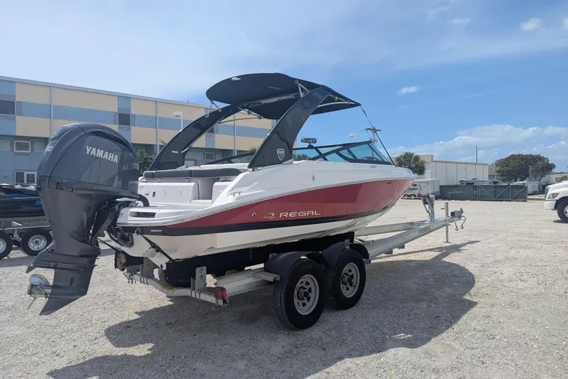 Slide: The Image of 2025 Regal 21 OBX boat with Yamaha engine on trailer, parked outdoors. - 5