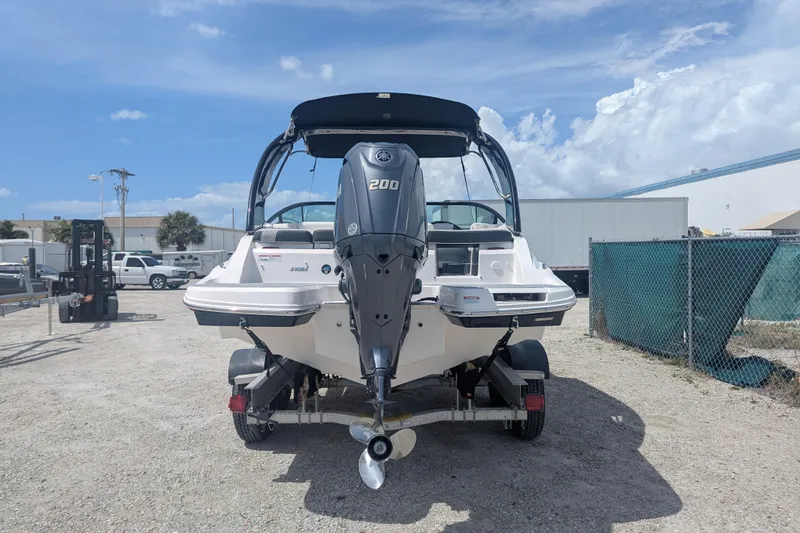 Slide: The Image of 2025 Regal 21 OBX boat with Yamaha 200 engine, parked outdoors on a sunny day. - 6