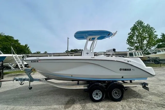 Slide: The Image of 2024 Yamaha Boats 222 FSH Sport E on trailer, side view, outdoors. - 1