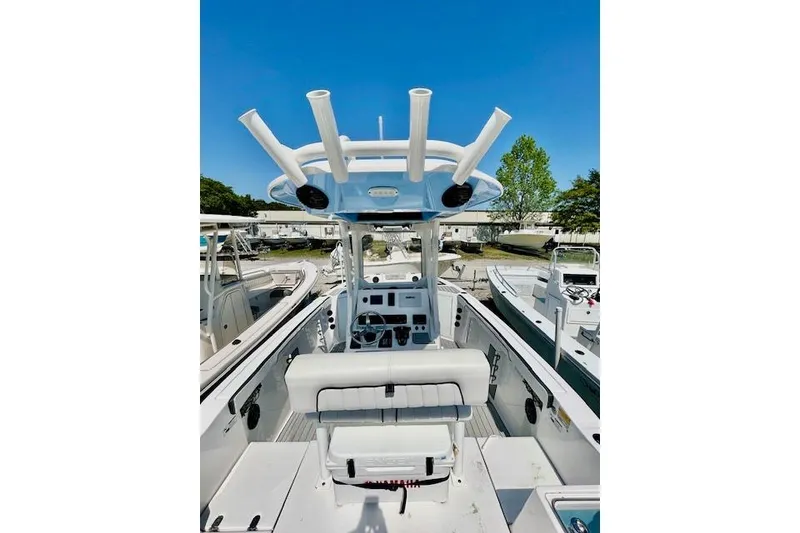 Slide: The Image of 2024 Yamaha Boats 222 FSH Sport E interior with steering console and rod holders. - 10