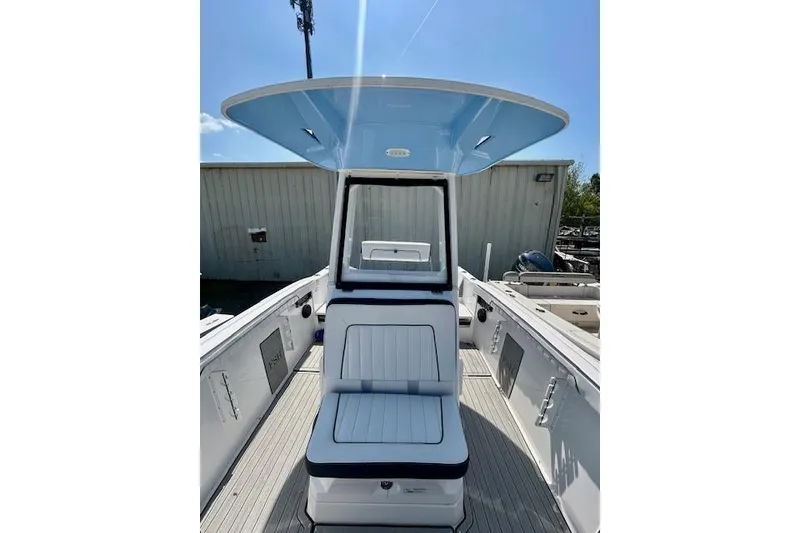 Slide: The Image of 2024 Yamaha Boats 222 FSH Sport E, center console view, blue canopy, modern design. - 13