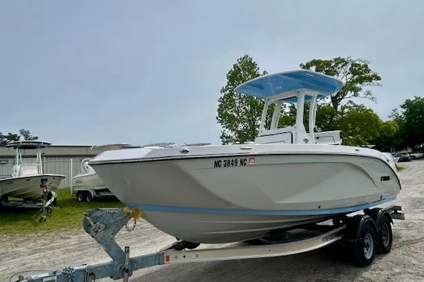 Slide: The Image of 2024 Yamaha Boats 222 FSH Sport E on trailer, parked outdoors. - 2