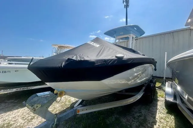 Slide: The Image of 2024 Yamaha Boats 222 FSH Sport E covered on trailer, outdoor display. - 6