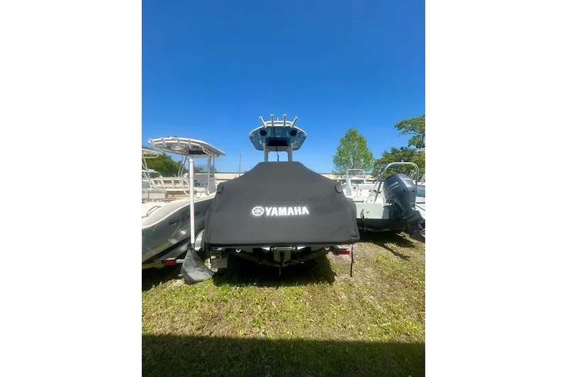 Slide: The Image of 2024 Yamaha Boats 222 FSH Sport E covered, parked outdoors under clear blue sky. - 7